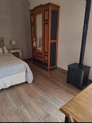 a bedroom with a bed and a wooden floor at Cabañas Posada del Angel in Villa Serranita
