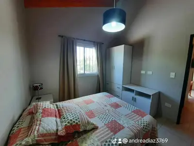 a bedroom with a bed and a dresser and a window at Alojamiento Premium en Las Marias De Cura Brochero in Villa Cura Brochero