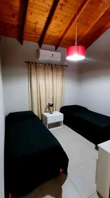 a room with a bed and a table and a light at Alojamiento Premium en Las Marias De Cura Brochero in Villa Cura Brochero
