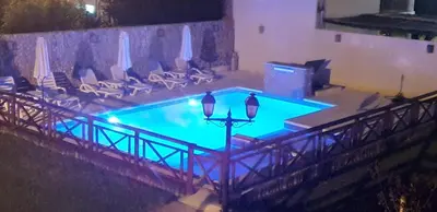 a large swimming pool with chairs and umbrellas at Alojamiento Premium en Las Marias De Cura Brochero in Villa Cura Brochero