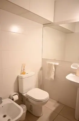 a white bathroom with a toilet and a sink at Unique & Cozy Apt in Cordobas heart in Cordoba