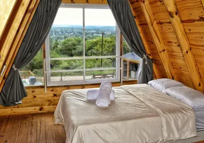 a bedroom with a bed and a large window at Alpinas Iguazu in Bialet Massé