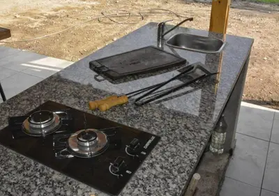 a kitchen counter with a stove and a sink at Alpinas Iguazu in Bialet Massé