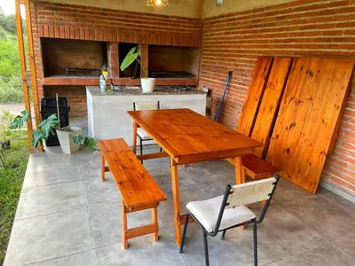 a wooden table and chairs on a patio at Alpinas Iguazu in Bialet Massé