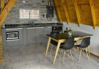 a kitchen with a table and chairs in it at Alpinas Iguazu in Bialet Massé