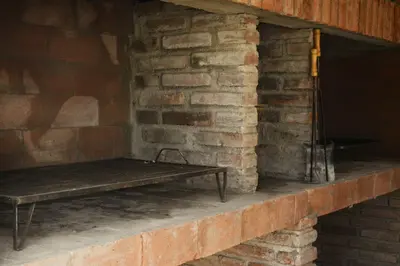 a wooden bench sitting on a brick wall at Alpinas Iguazu in Bialet Massé
