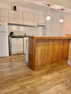 a kitchen with white appliances and a wooden counter at La Serena Villa Rumipal - Cordoba in Villa Rumipal