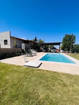 a swimming pool in a yard next to a house at La Serena Villa Rumipal - Cordoba in Villa Rumipal
