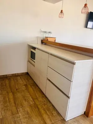 a kitchen with white cabinets and a counter top at La Serena Villa Rumipal - Cordoba in Villa Rumipal
