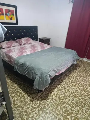 a bedroom with a bed with a blue blanket on it at Departamento azules in Cordoba