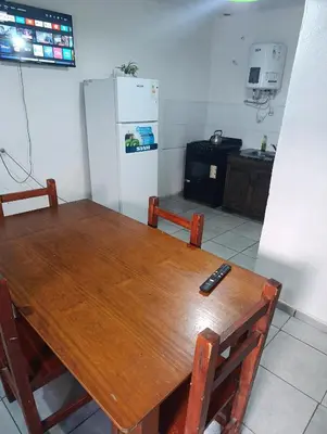 a kitchen with a wooden table and a refrigerator at Departamento azules in Cordoba