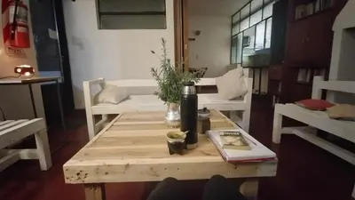 a coffee table with a bottle of wine on it at Gen Viajero Hostel in Merlo