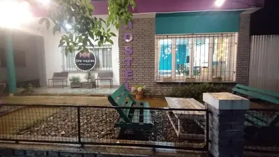 a house with a bench and a sign on it at Gen Viajero Hostel in Merlo