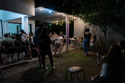 a group of people standing outside of a restaurant at night at Gen Viajero Hostel in Merlo