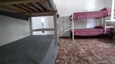 a room with two bunk beds and a wooden floor at Gen Viajero Hostel in Merlo