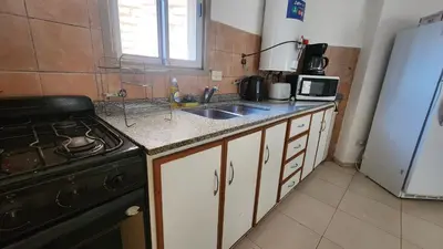 a kitchen with a sink and a stove and a refrigerator at Chacabuco Nueva Cordoba in Cordoba