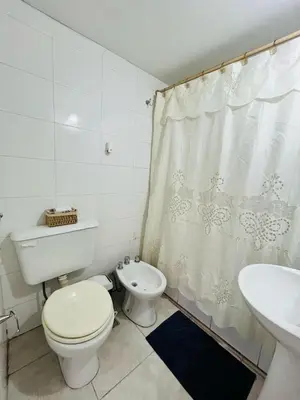 a white bathroom with a toilet and a sink at Depto Ángeles Fragueiro in Cordoba