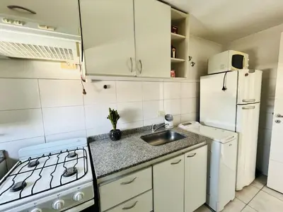 a small kitchen with a sink and a refrigerator at Depto Ángeles Fragueiro in Cordoba