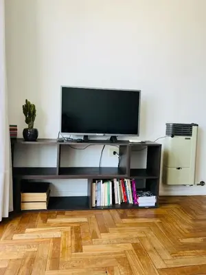 a flat screen tv sitting on top of a entertainment center at Depto Ángeles Fragueiro in Cordoba