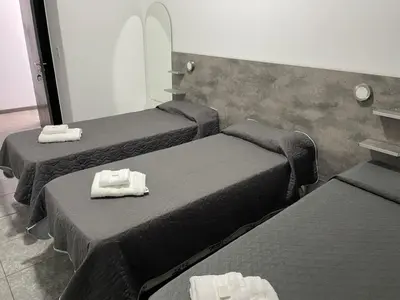 a room with three beds with towels on them at alojamiento bella vista in Villa Carlos Paz