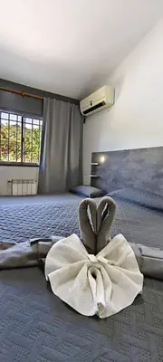 a room with a bed with a large white robe at alojamiento bella vista in Villa Carlos Paz