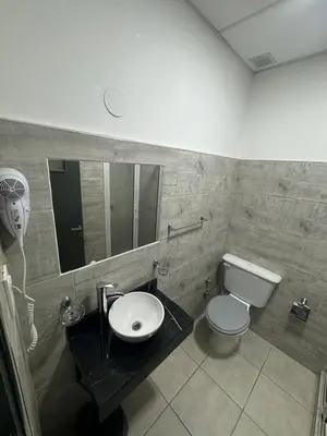 a bathroom with a toilet and a sink and a mirror at alojamiento bella vista in Villa Carlos Paz