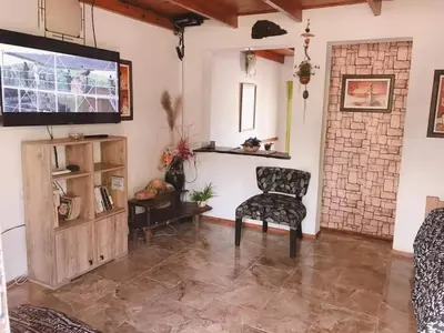 a living room with a chair and a flat screen tv at Naiarai Cordoba in Santa María