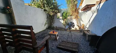 a patio with two wooden benches and a swing at Naiarai Cordoba in Santa María