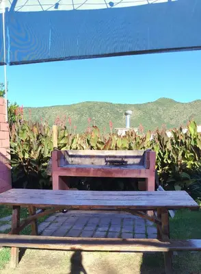a wooden bench sitting in front of a garden at Complejo ELMA in San Antonio de Arredondo