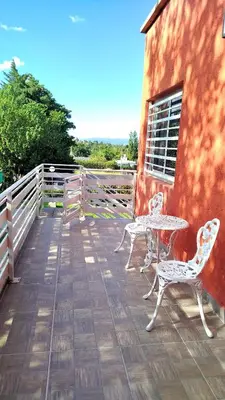 a patio with two chairs and a table and a fence at Complejo ELMA in San Antonio de Arredondo