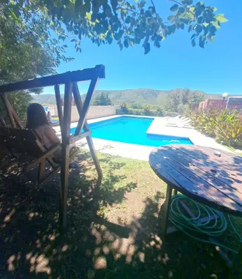 a woman sitting in a chair next to a picnic table at Complejo ELMA in San Antonio de Arredondo