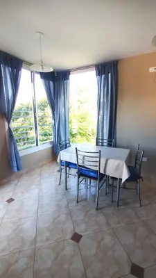 a dining room with a table and chairs and windows at Complejo ELMA in San Antonio de Arredondo