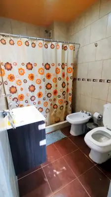 a bathroom with a toilet and a shower curtain at Complejo ELMA in San Antonio de Arredondo
