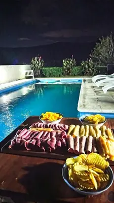 a tray of food on a table next to a swimming pool at Complejo ELMA in San Antonio de Arredondo