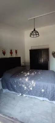 a bedroom with a bed and a light fixture at La Casita de Lucía in Almafuerte