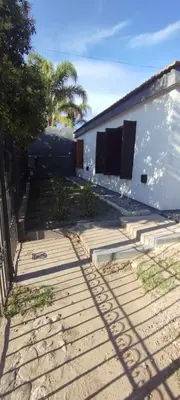 a yard with a white building and a fence at La Casita de Lucía in Almafuerte