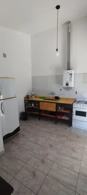 a kitchen with a table and a stove and a refrigerator at La Casita de Lucía in Almafuerte