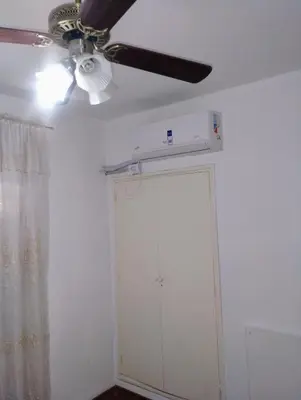 a ceiling fan and a door in a room at departamento de excelente ubicación, cochera , aire acondicionado in Villa Carlos Paz