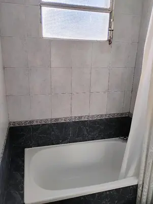 a white bath tub in a bathroom with a window at departamento de excelente ubicación, cochera , aire acondicionado in Villa Carlos Paz