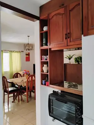 a kitchen and dining room with a table and cabinets at departamento de excelente ubicación, cochera , aire acondicionado in Villa Carlos Paz