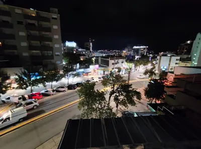 a city street at night with cars on the road at Departamento luna in Villa Carlos Paz