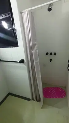a shower with a pink seat in a room at Departamento luna in Villa Carlos Paz