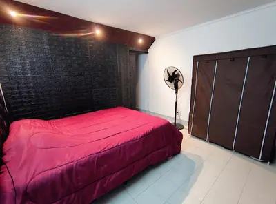 a bedroom with a red bed and a brick wall at Departamento luna in Villa Carlos Paz
