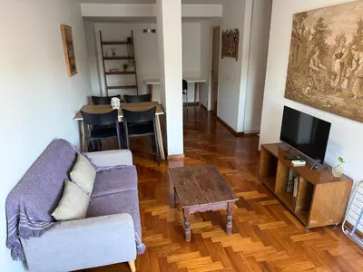 a living room with a couch and a tv and a table at Departamento Nueva Córdoba in Cordoba