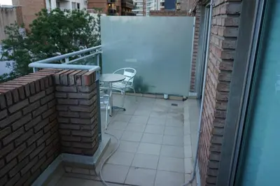 a balcony with a table and chairs on a building at Departamento Nueva Córdoba in Cordoba