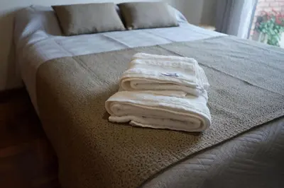 a pile of towels sitting on the end of a bed at Departamento Nueva Córdoba in Cordoba