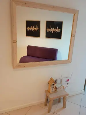 a mirror on the wall of a room with a bench at Comfort and Convenience Apartment Near Park in Cordoba