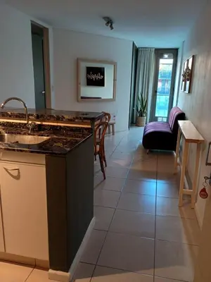 a kitchen with a sink and a living room at Comfort and Convenience Apartment Near Park in Cordoba