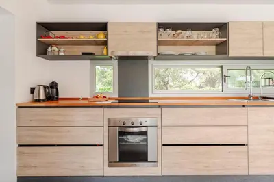 a kitchen with wooden cabinets and an oven at Casa con piscina privada y vistas al Cerro Champaquí in San Javier