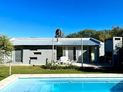 a house with a swimming pool in front of it at Casa con piscina privada y vistas al Cerro Champaquí in San Javier